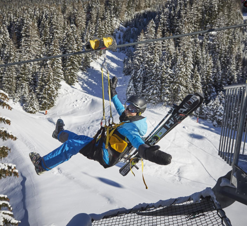 Ein Skifahrer gleitend auf einer Zipline